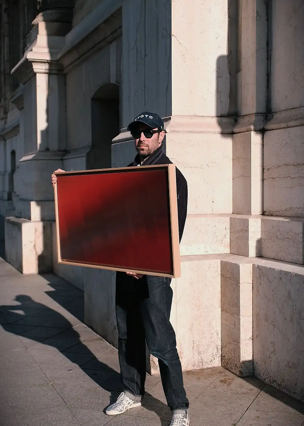 Anthony Celerier presents the artwork Lova, coloured blades in a frame, in front of a fountain.